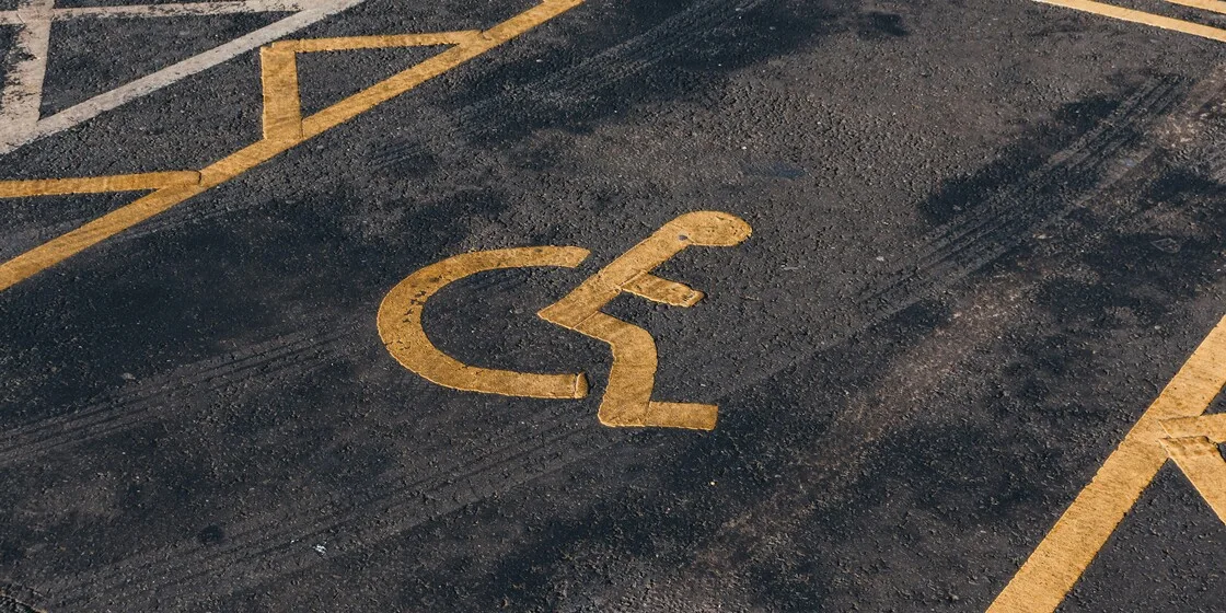 A handicap parking space with a yellow wheelchair symbol
