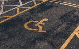 © Photographer: Jakub Pabis
Quelle: Unsplash A handicap parking space with a yellow wheelchair symbol