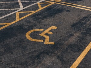© Photographer: Jakub Pabis
Quelle: Unsplash A handicap parking space with a yellow wheelchair symbol