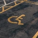 A handicap parking space with a yellow wheelchair symbol