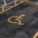 A handicap parking space with a yellow wheelchair symbol