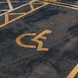 A handicap parking space with a yellow wheelchair symbol